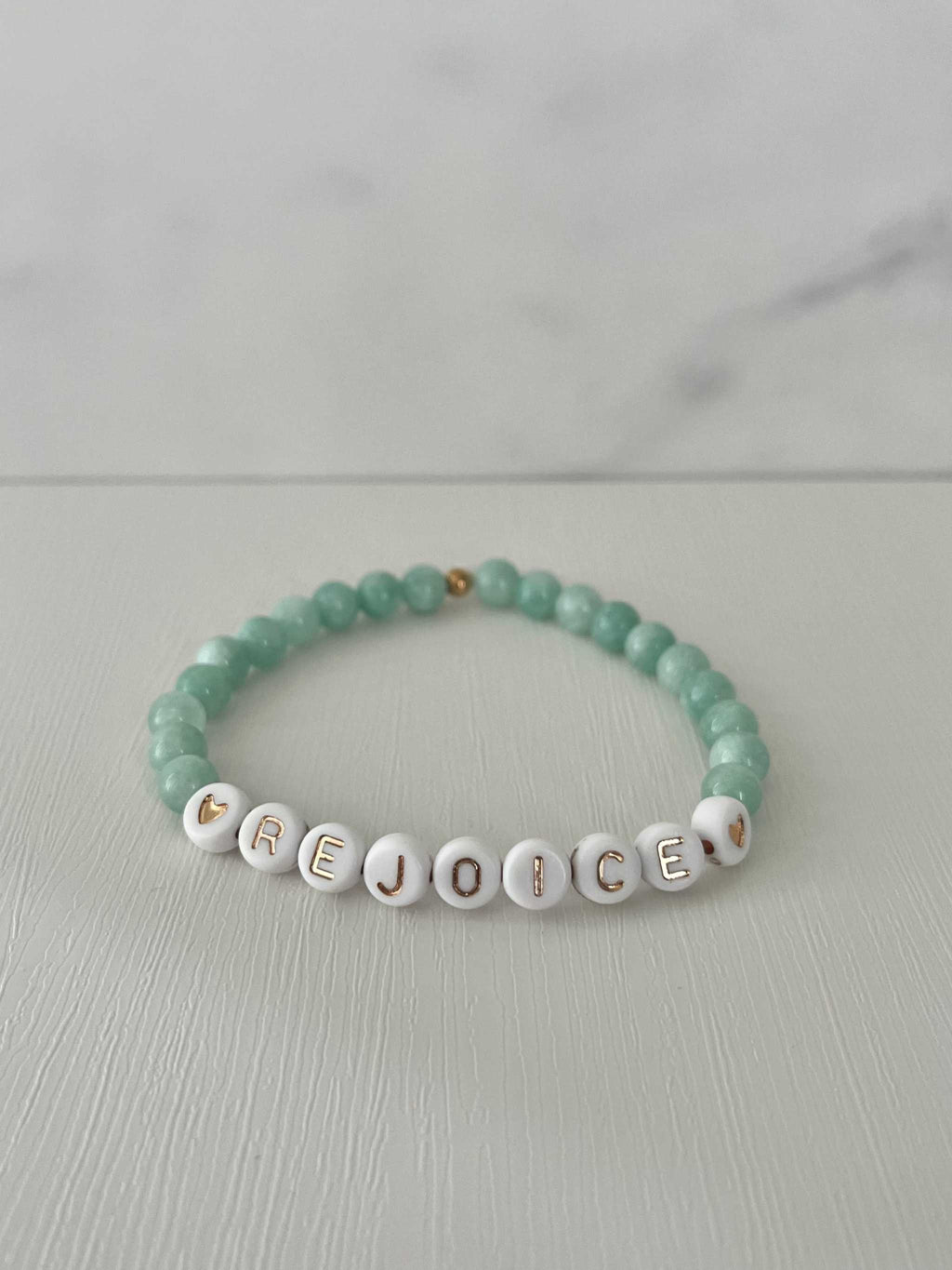 Green jade bead bracelet with white letter beads spelling REJOICE