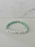 Green jade bead bracelet with white letter beads spelling REJOICE