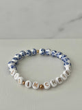 Blue bead bracelet with white letter beads spelling IN CHRIST and blue floral accents