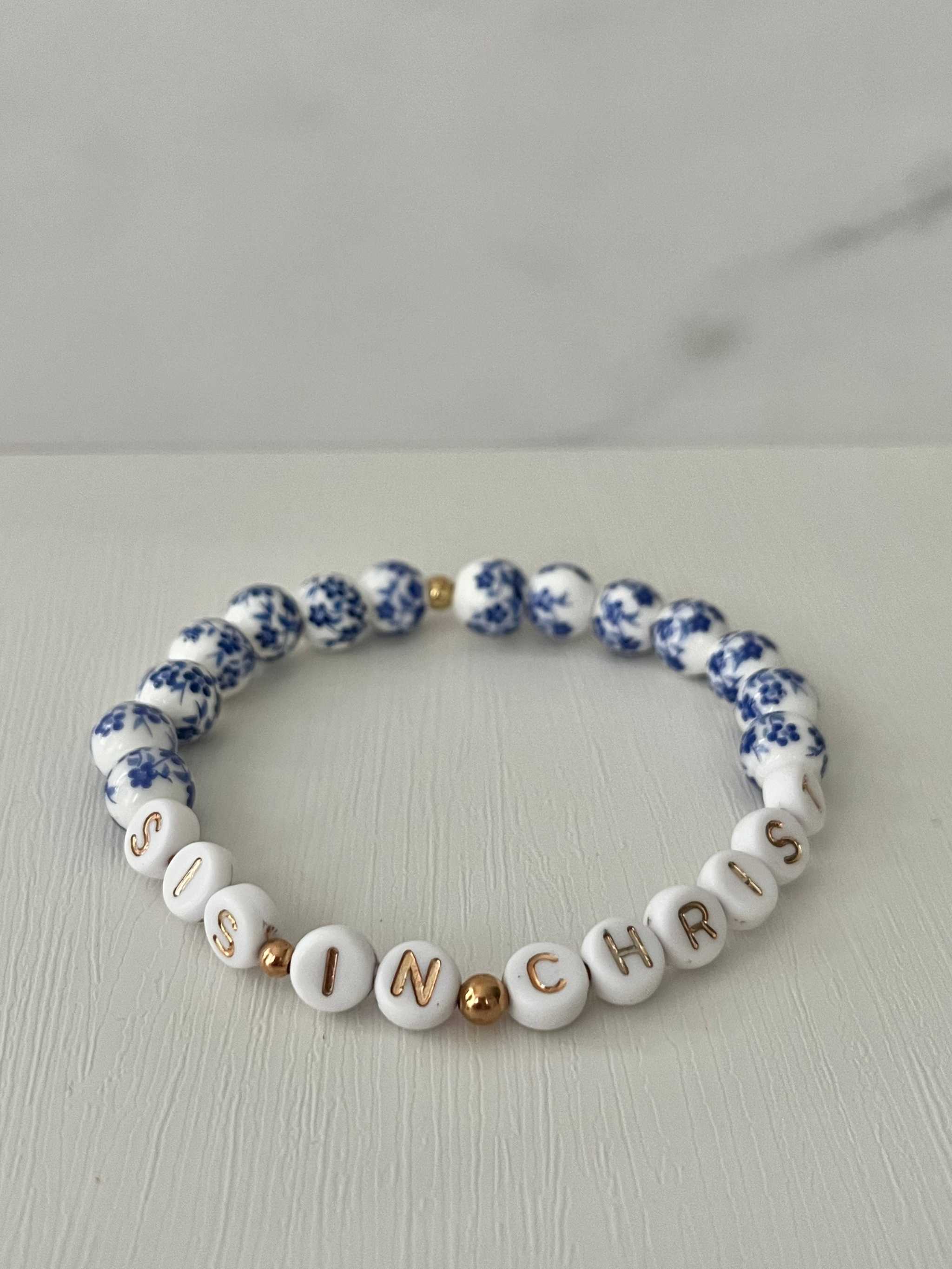 Blue bead bracelet with white letter beads spelling IN CHRIST and blue floral accents
