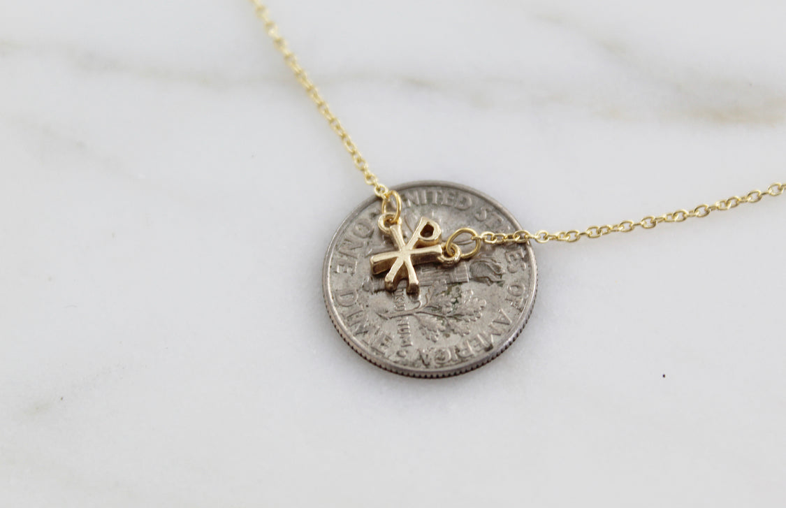 Gold coin-style pendant with Chi Rho emblem on a fine chain