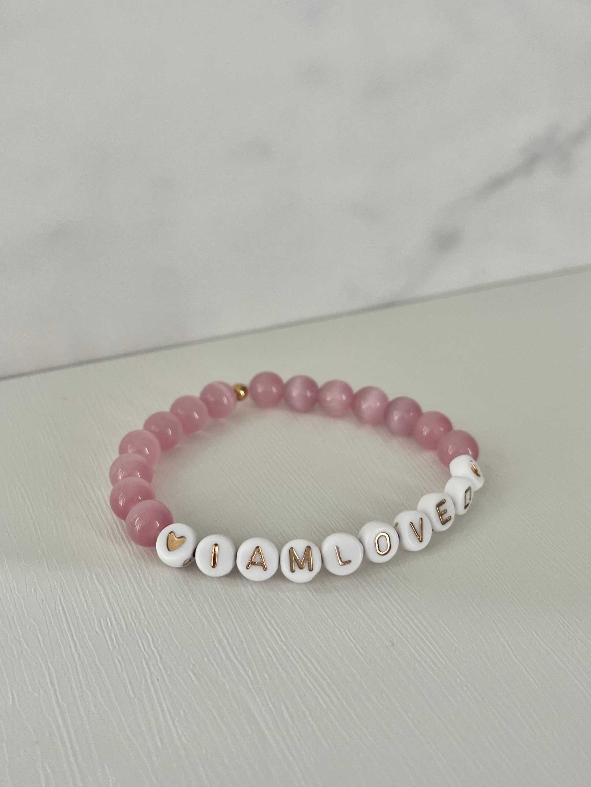 Pink beaded bracelet with 'I AM LOVED' letter beads and small gold bead