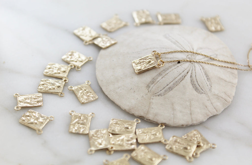 Scapular necklace with scattered rectangular gold-toned charms