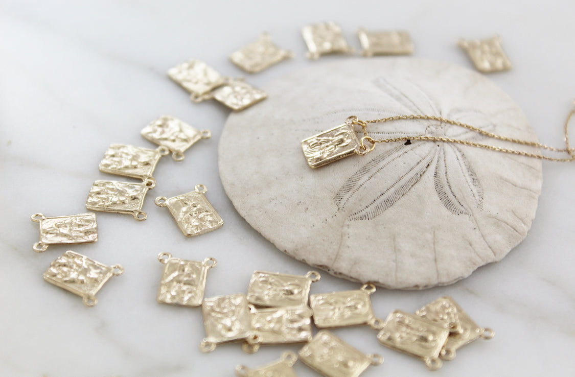 Scapular necklace with scattered rectangular gold-toned charms