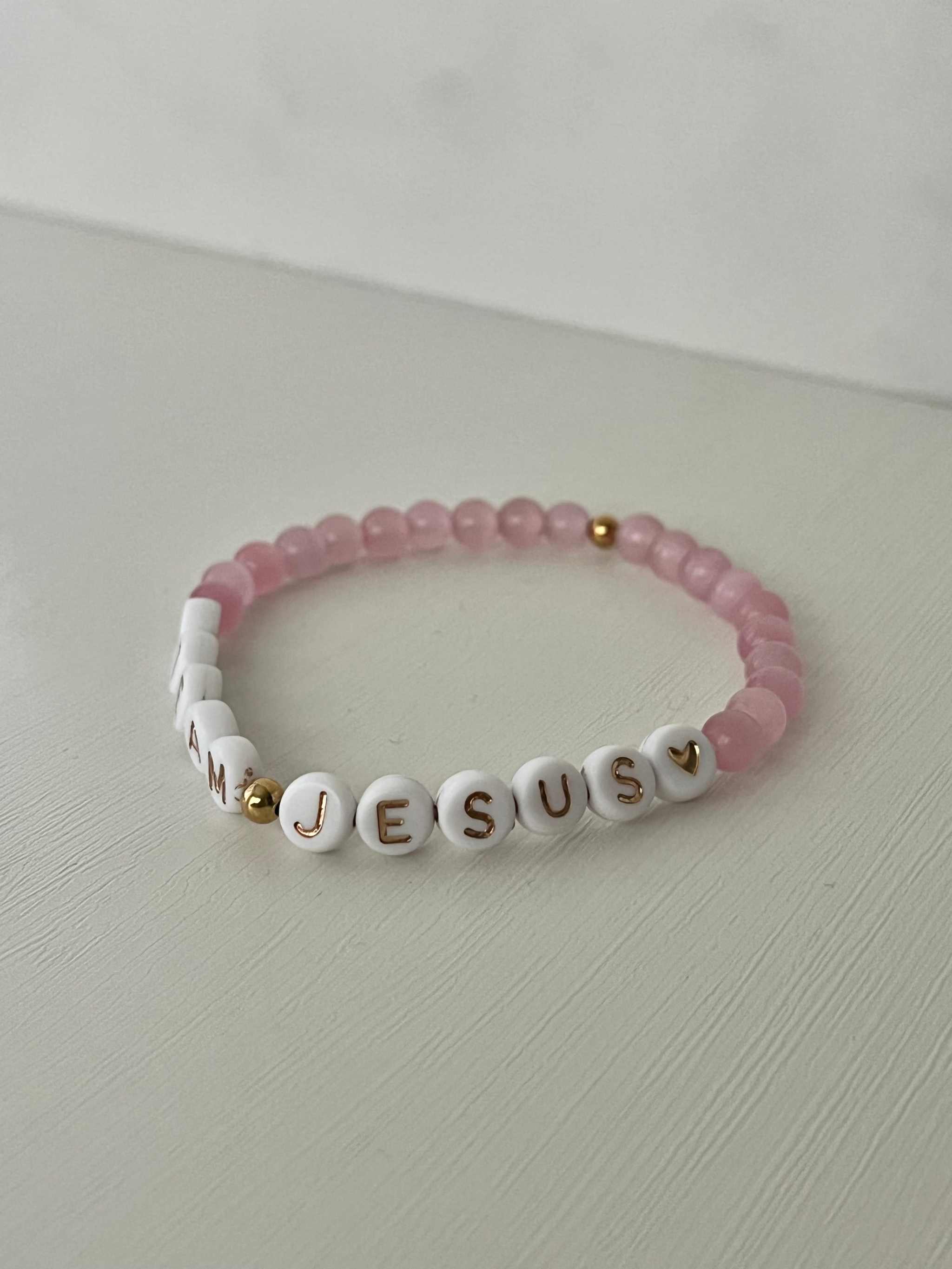 Opal-like iridescent beaded bracelet with pink beads and white letter charms spelling JESUS