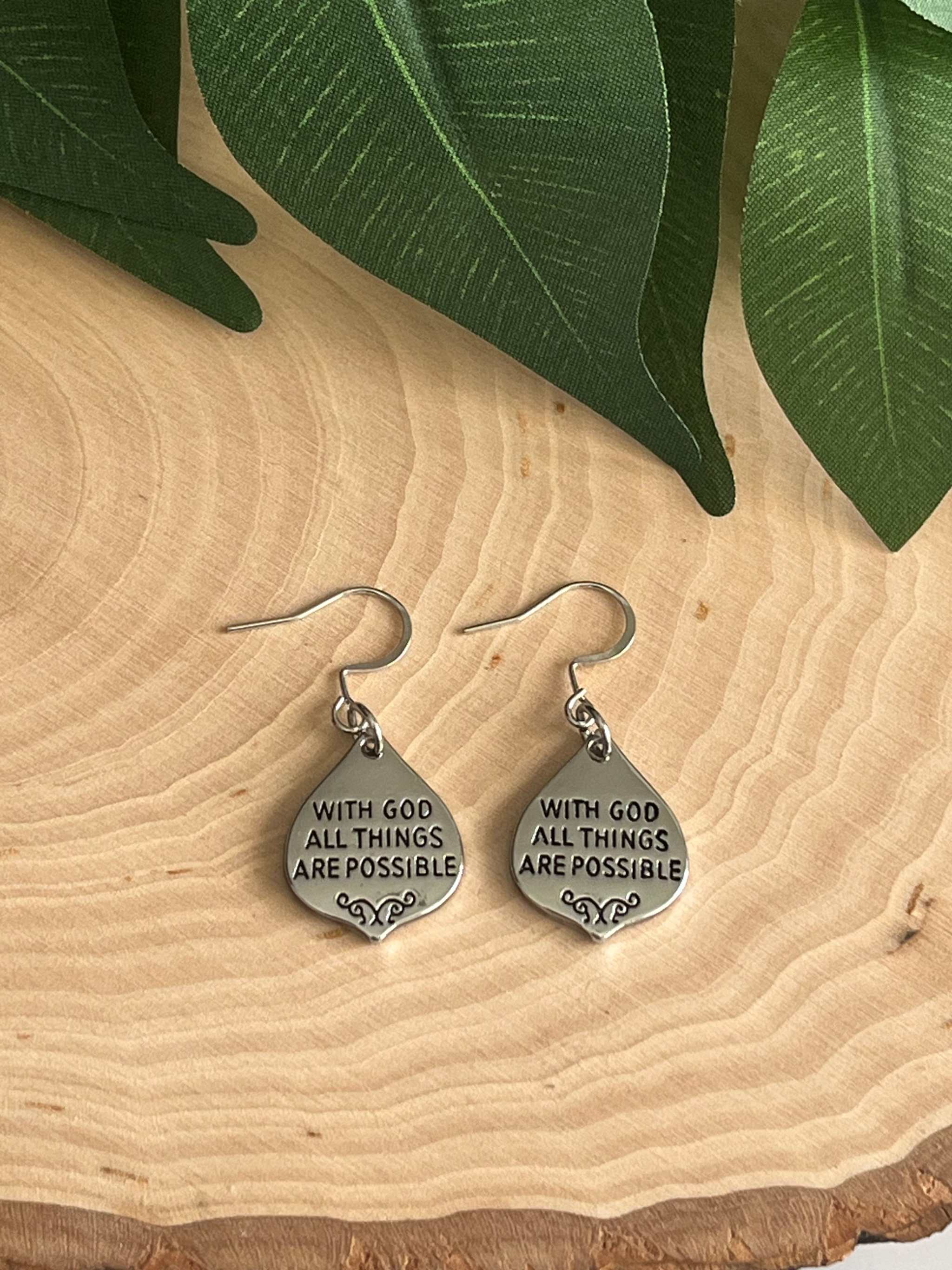Silver dangle earrings, round charms engraved “With God all things are possible”.