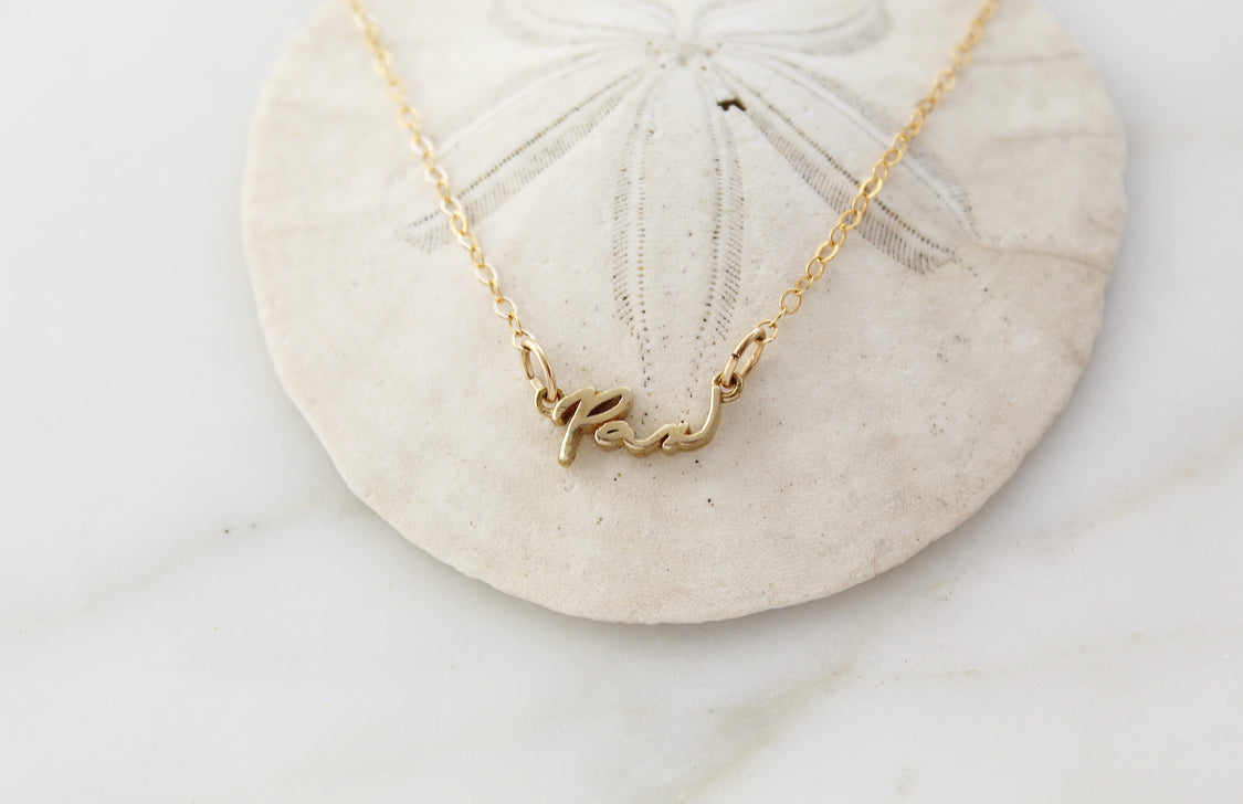 Gold Pax necklace cursive pendant on chain, centered