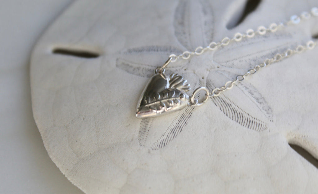 Sterling silver heart pendant necklace with raised heart details and fine link chain
