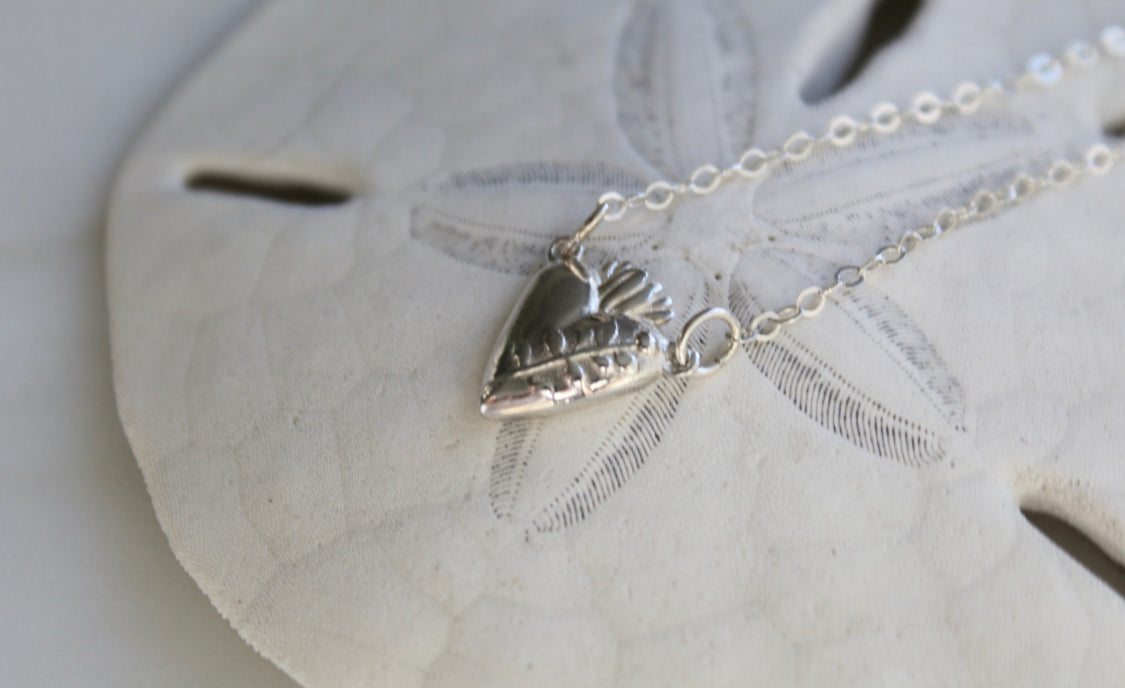 Sterling silver heart pendant necklace with raised heart details and fine link chain