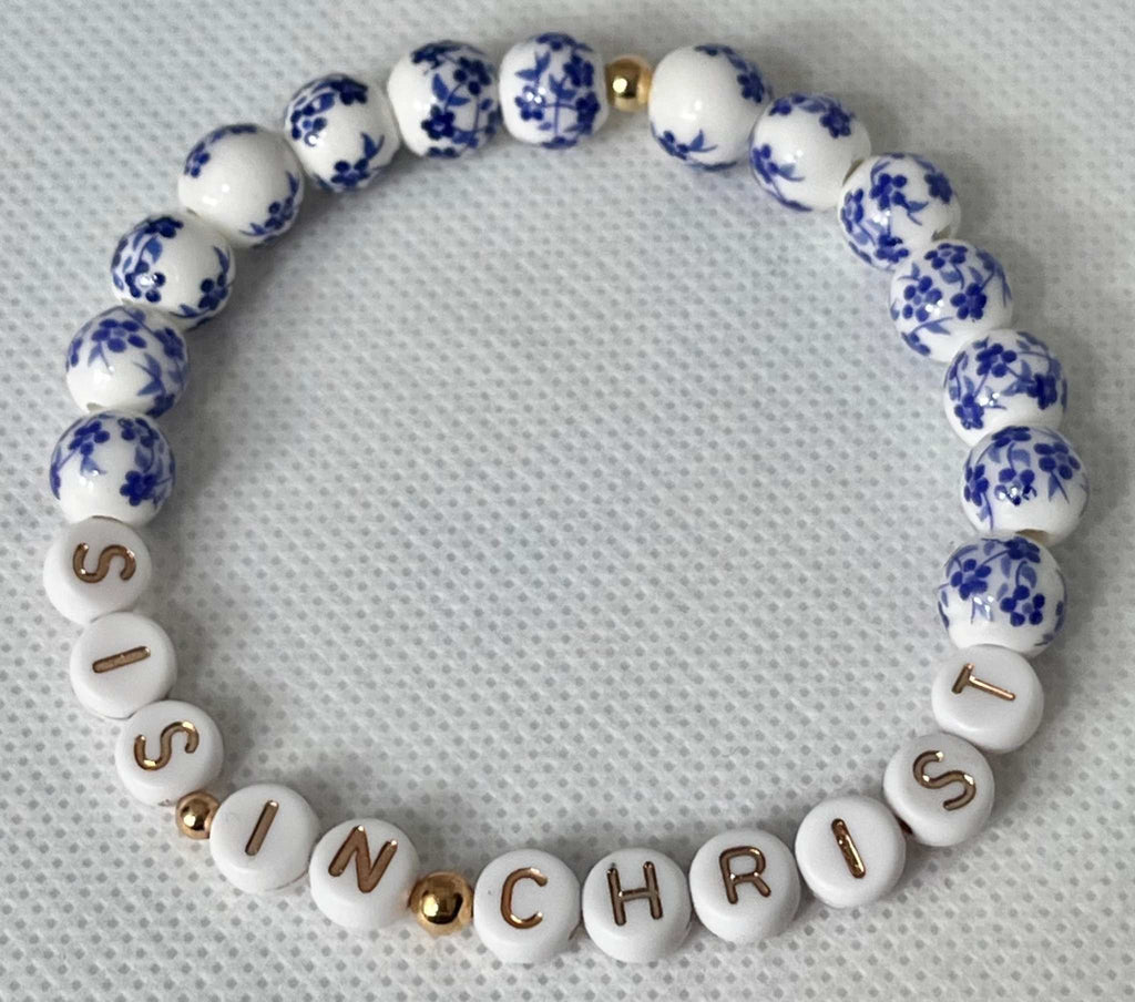 Blue bead bracelet with white letter beads spelling IN CHRIST and blue floral patterns