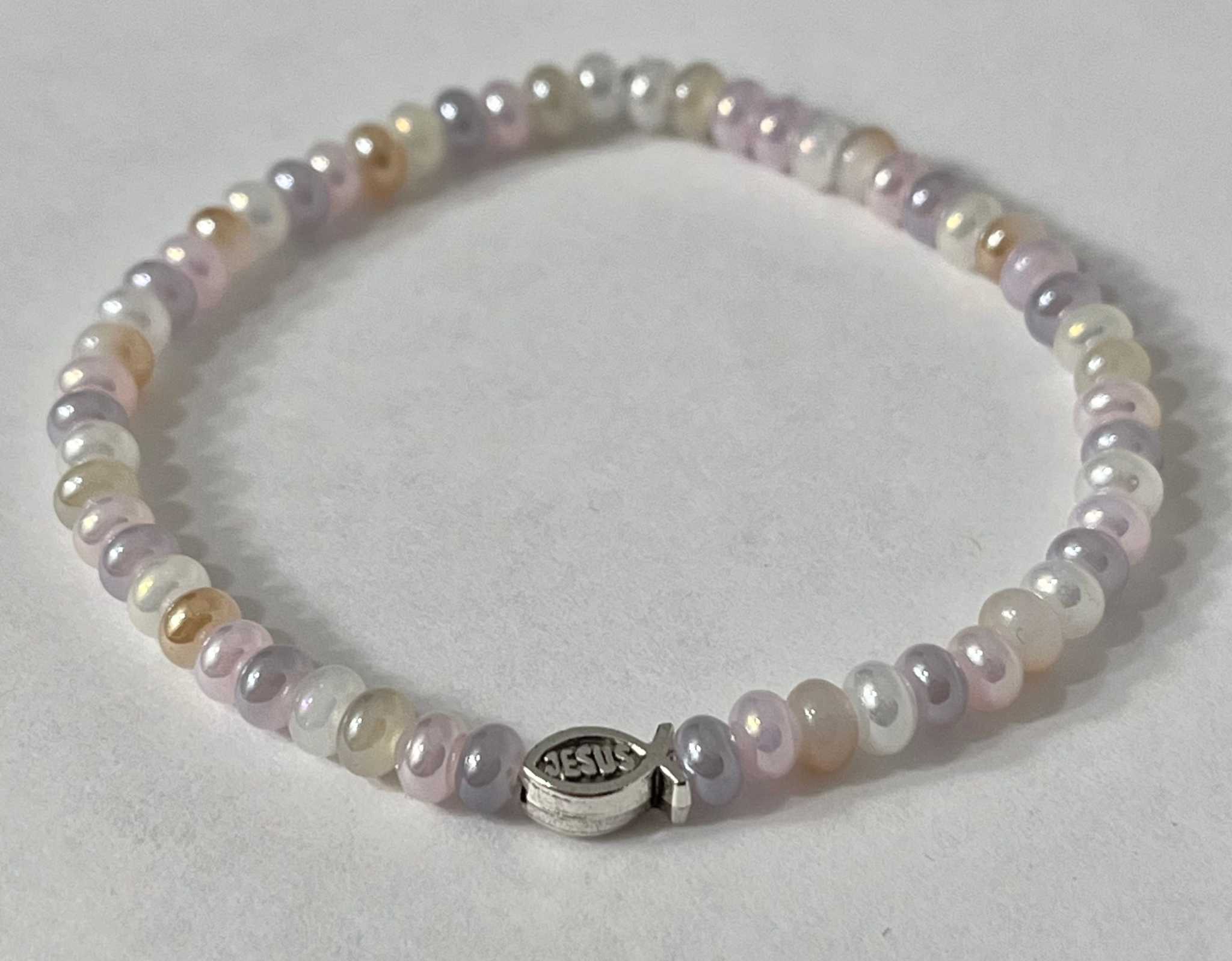 Bead bracelet with pastel purple and white beads and a round silver Jesus charm