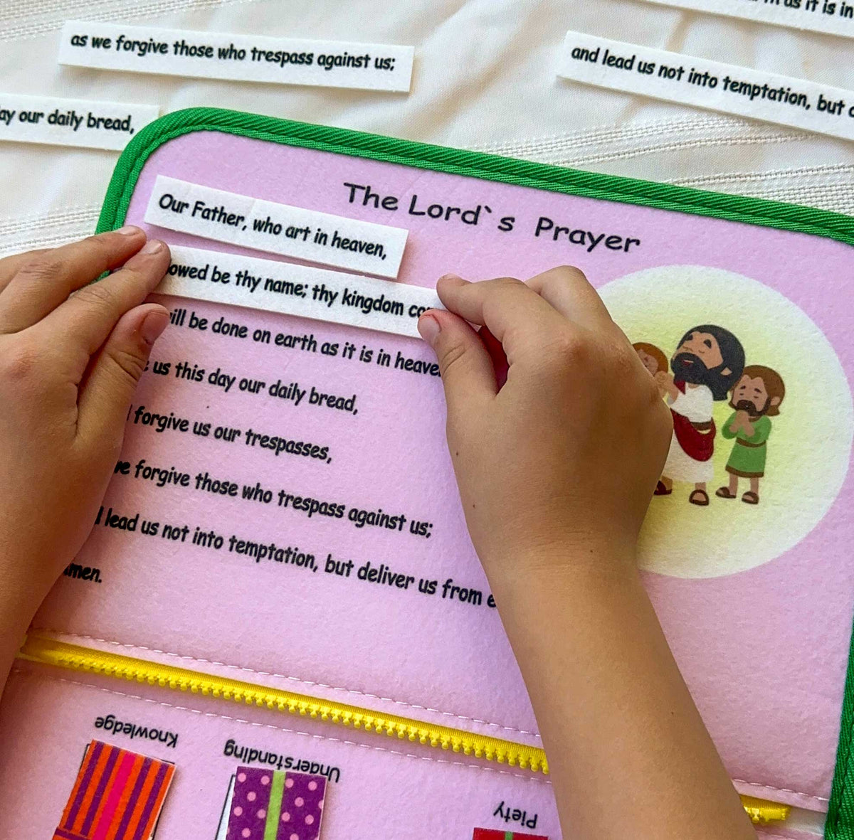 Close-up prayer page on felt busy book with hands reading and turning pieces