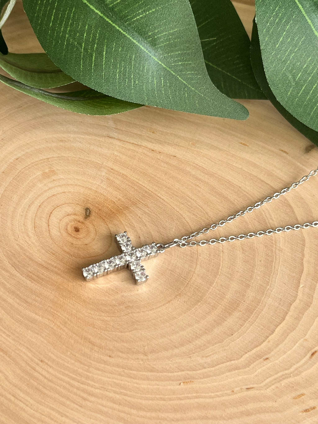 Silver rhinestone cross pendant necklace side view on fine chain