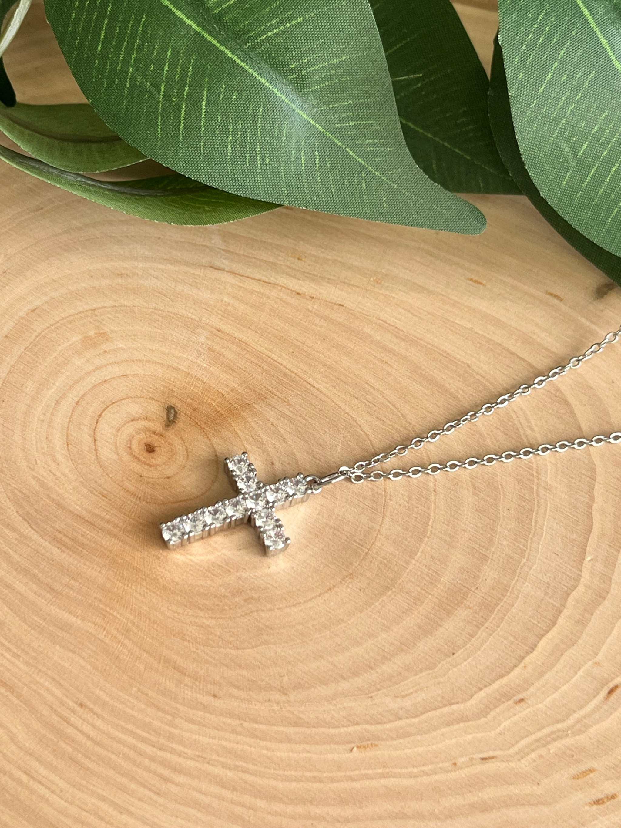 Silver rhinestone cross pendant necklace side view on fine chain