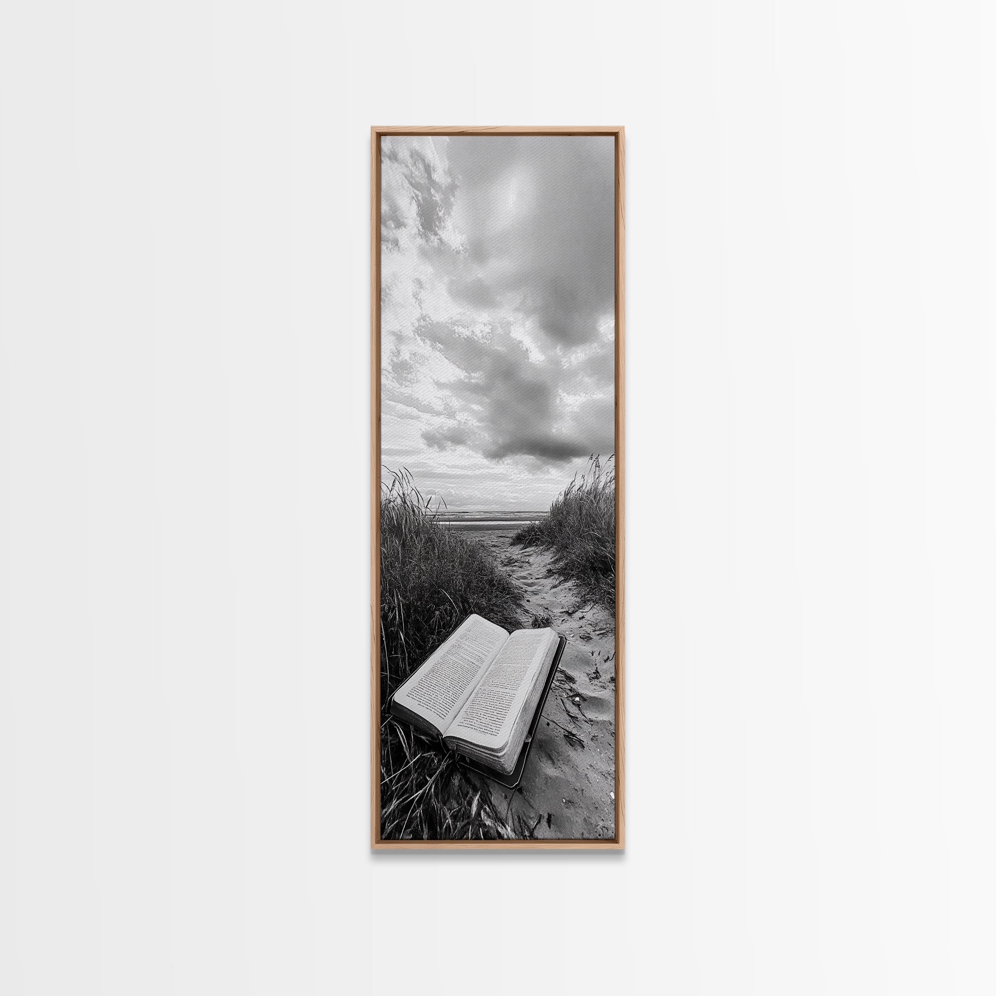 Light oak framed canvas print of open Bible on a sandy beach path under cloudy sky
