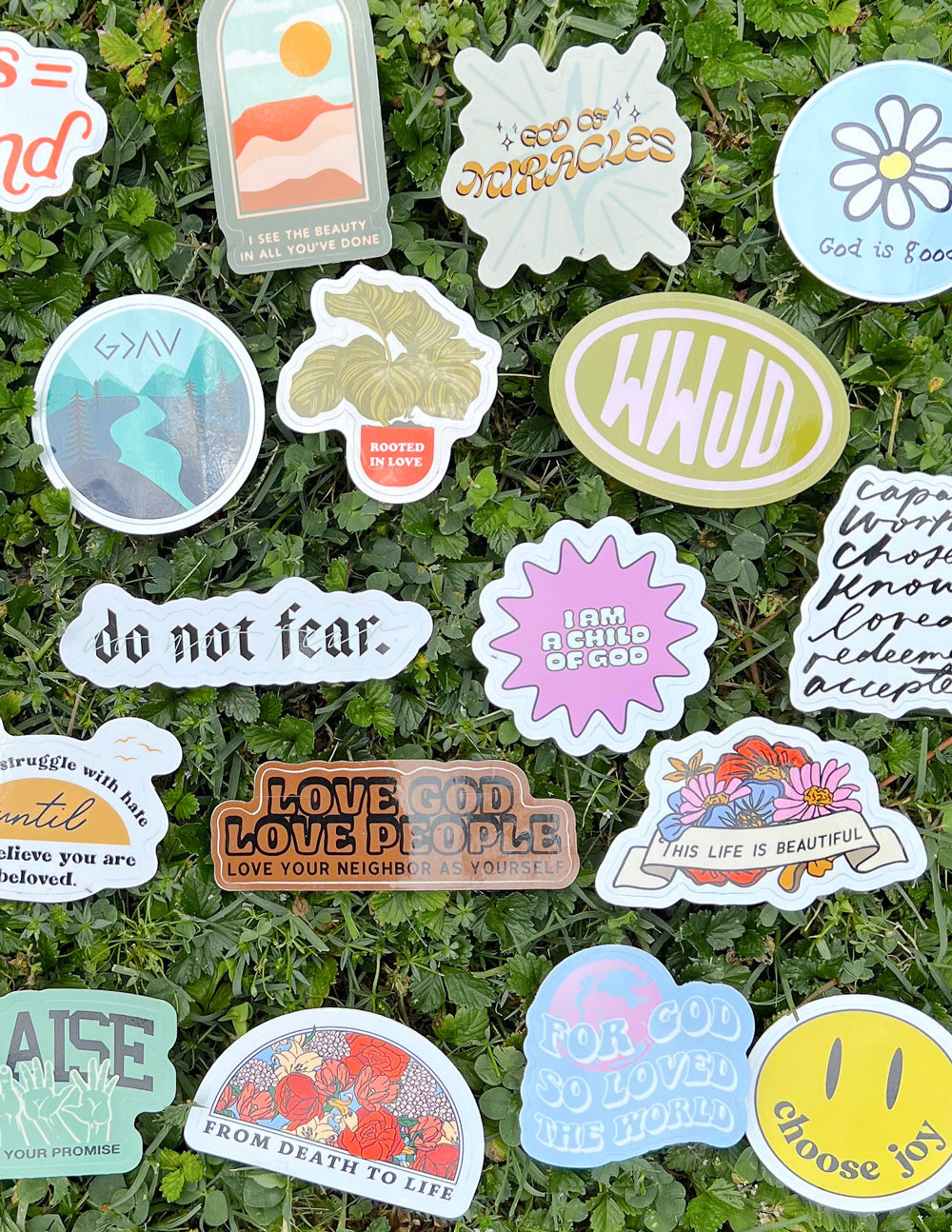 Faith-themed sticker set on greenery, with circular seals, flowers, and scripture quotes.