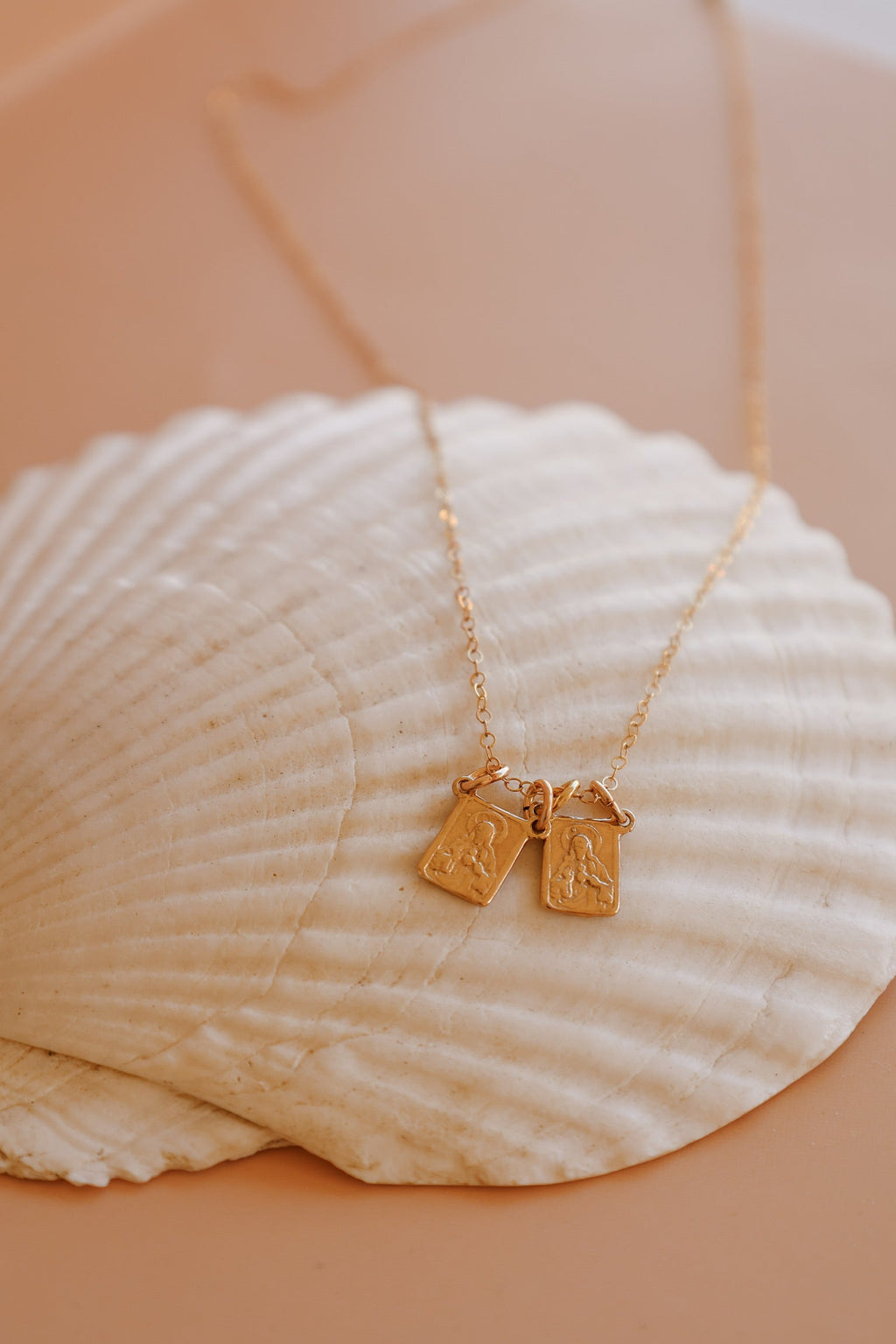 Scapular charm necklace with two small rectangular pendant charms on a gold chain