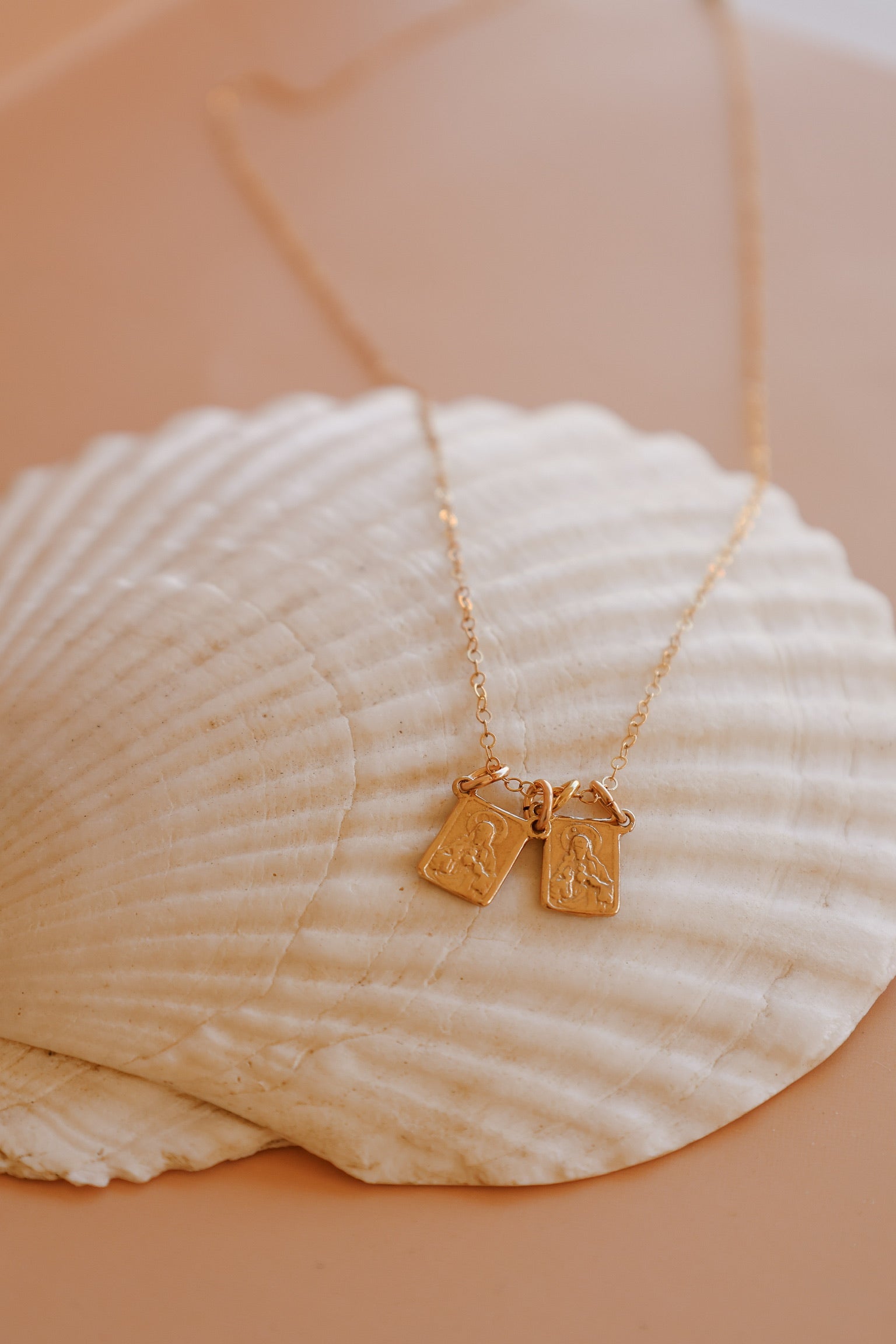 Scapular charm necklace with two small rectangular pendant charms on a gold chain