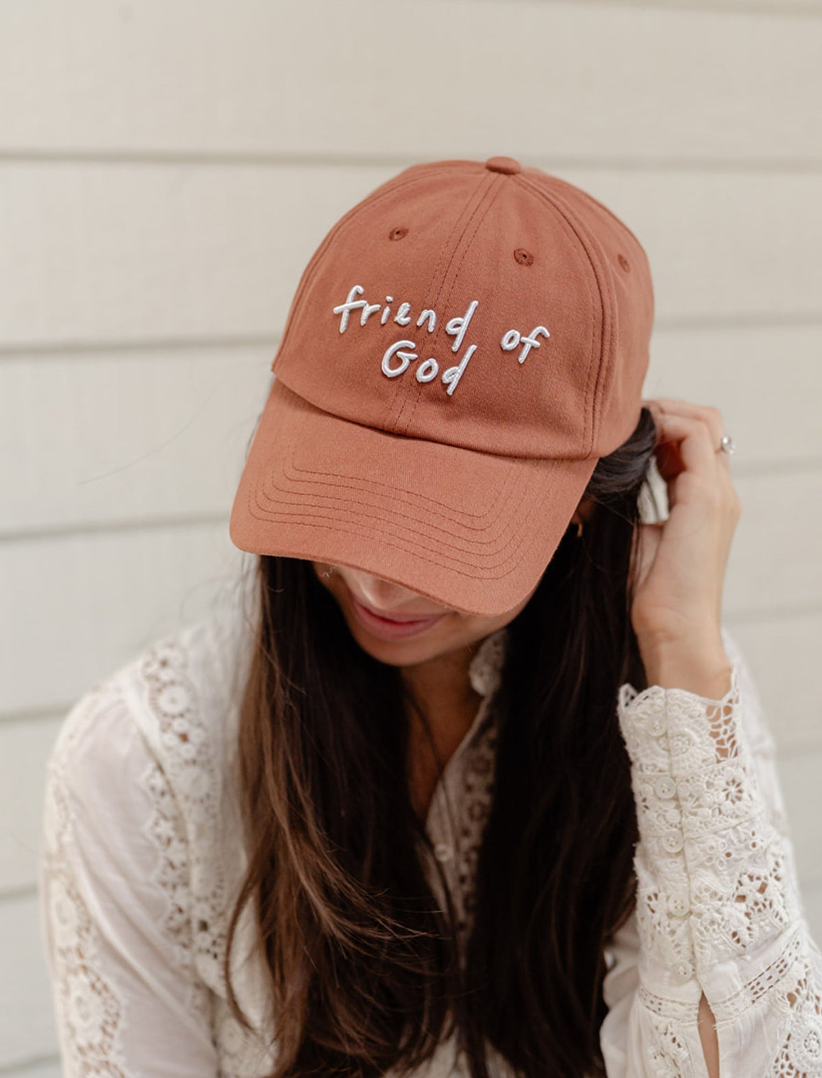 Rust baseball cap with embroidered 'Friend of God' text, curved brim