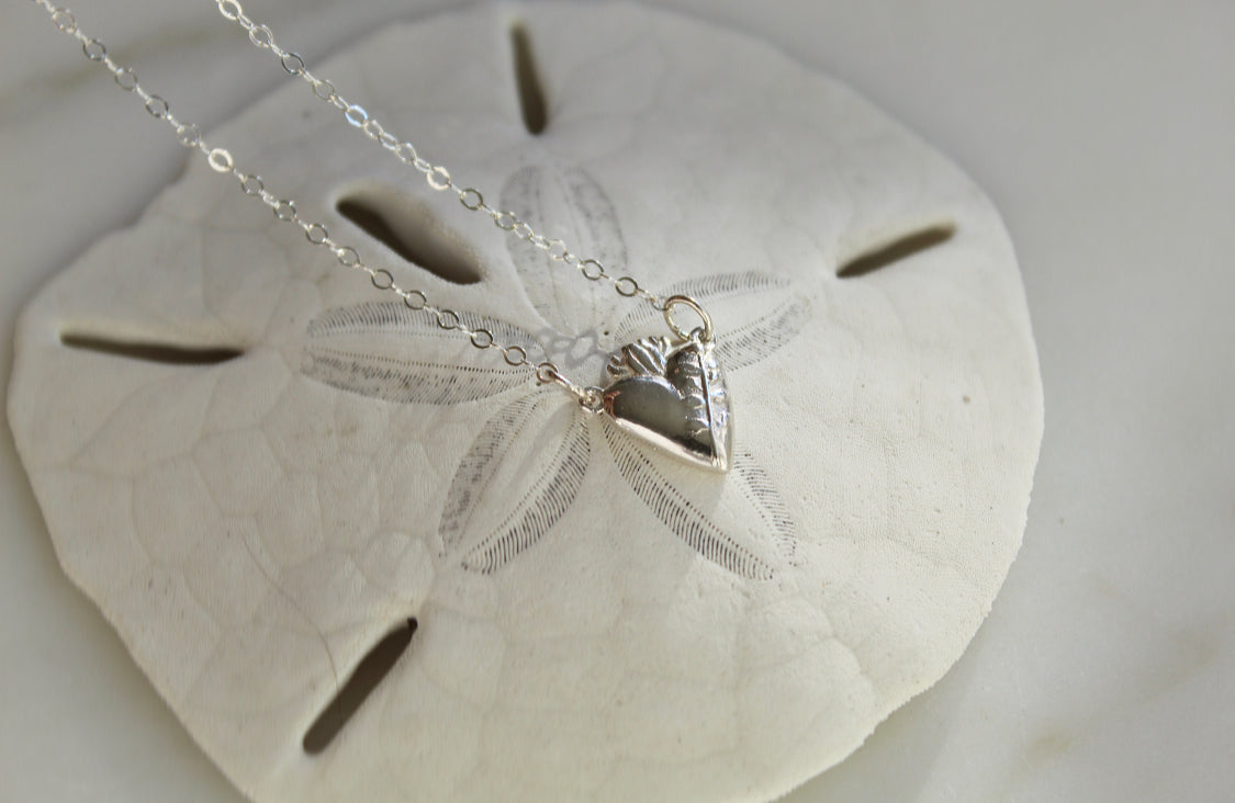 Sterling silver heart pendant necklace with bow-like accents on the heart and chain