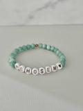 Jade green bead bracelet with white letter beads spelling CHOSEN