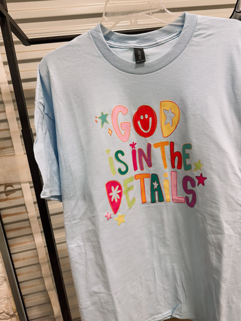Light blue T-shirt with colorful "God Is In The Details" front print