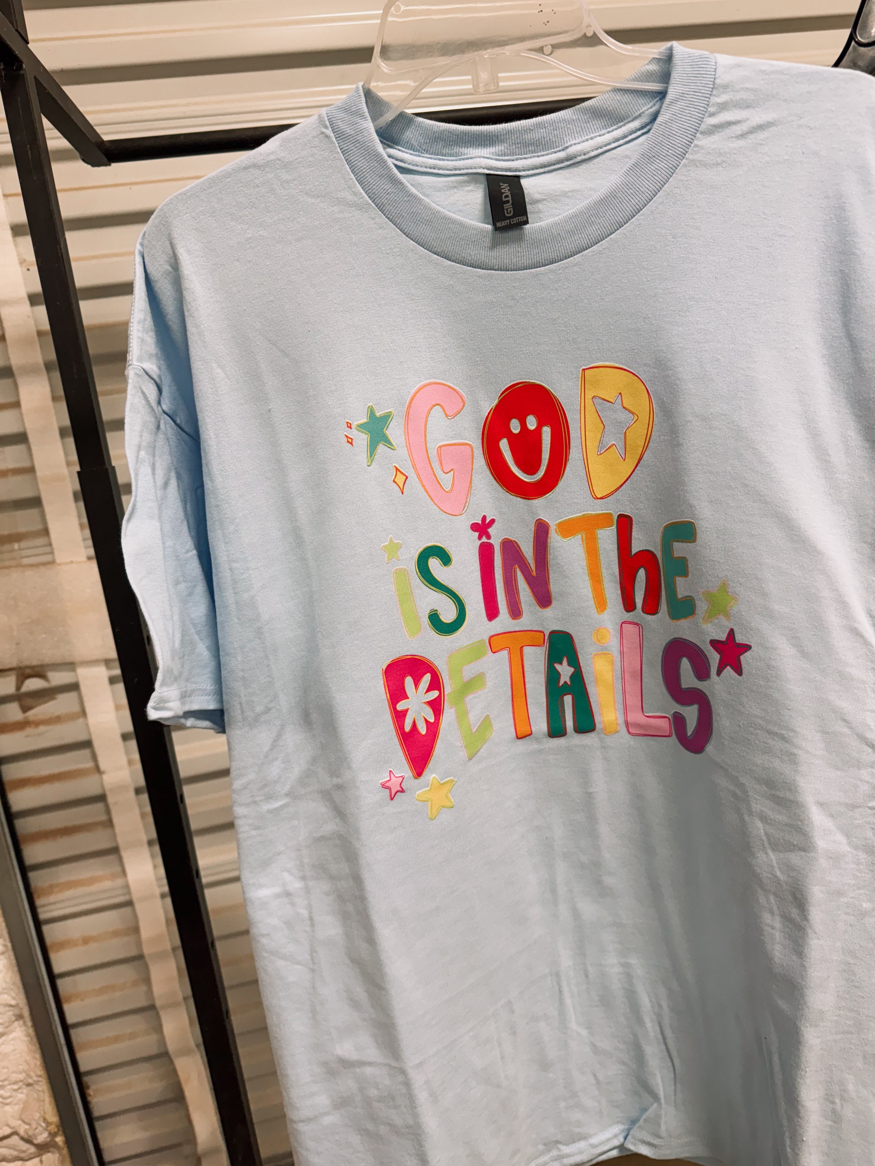 Light blue T-shirt with colorful "God Is In The Details" front print