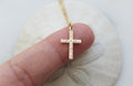 Gold cross pendant necklace with beaded chain, small square detailing on cross