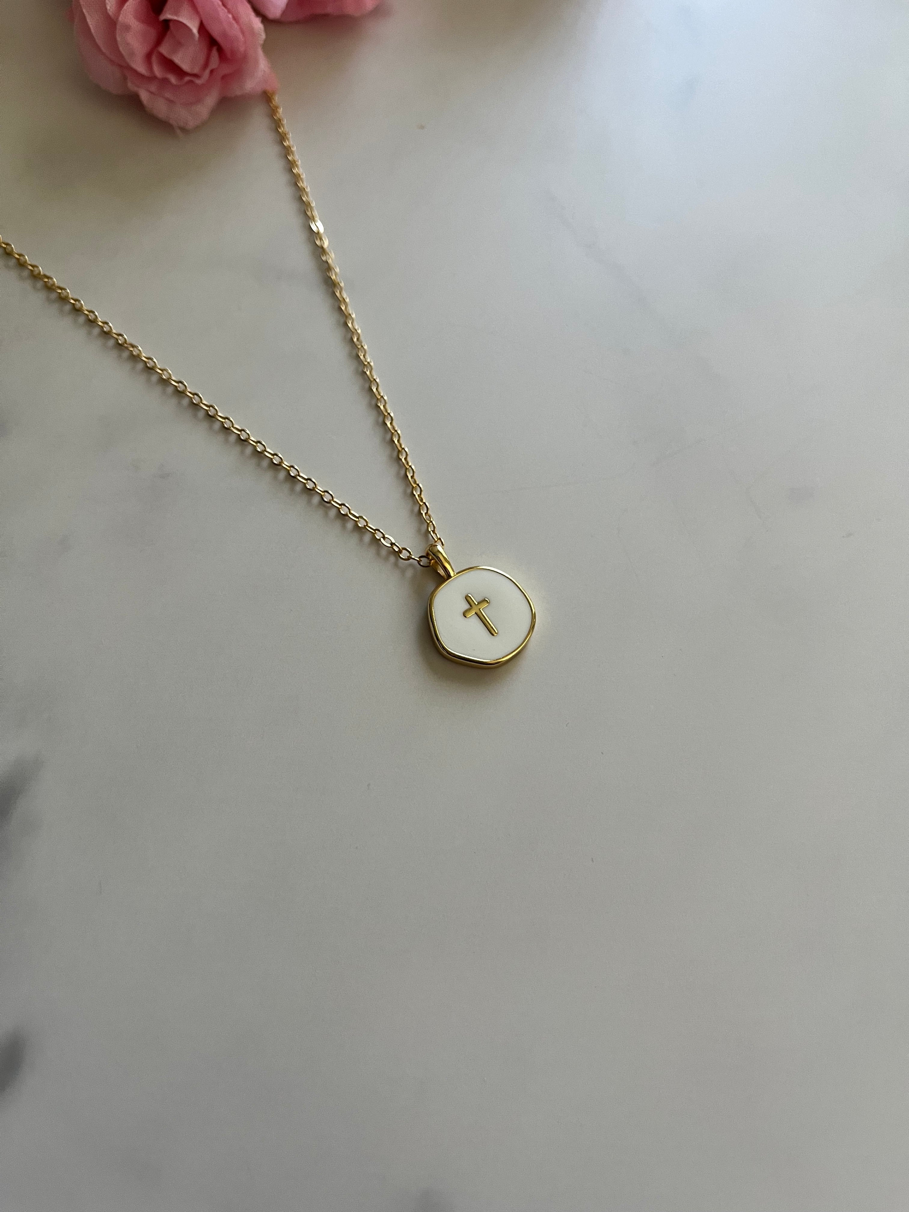 Gold cross pendant necklace with close view of round medallion