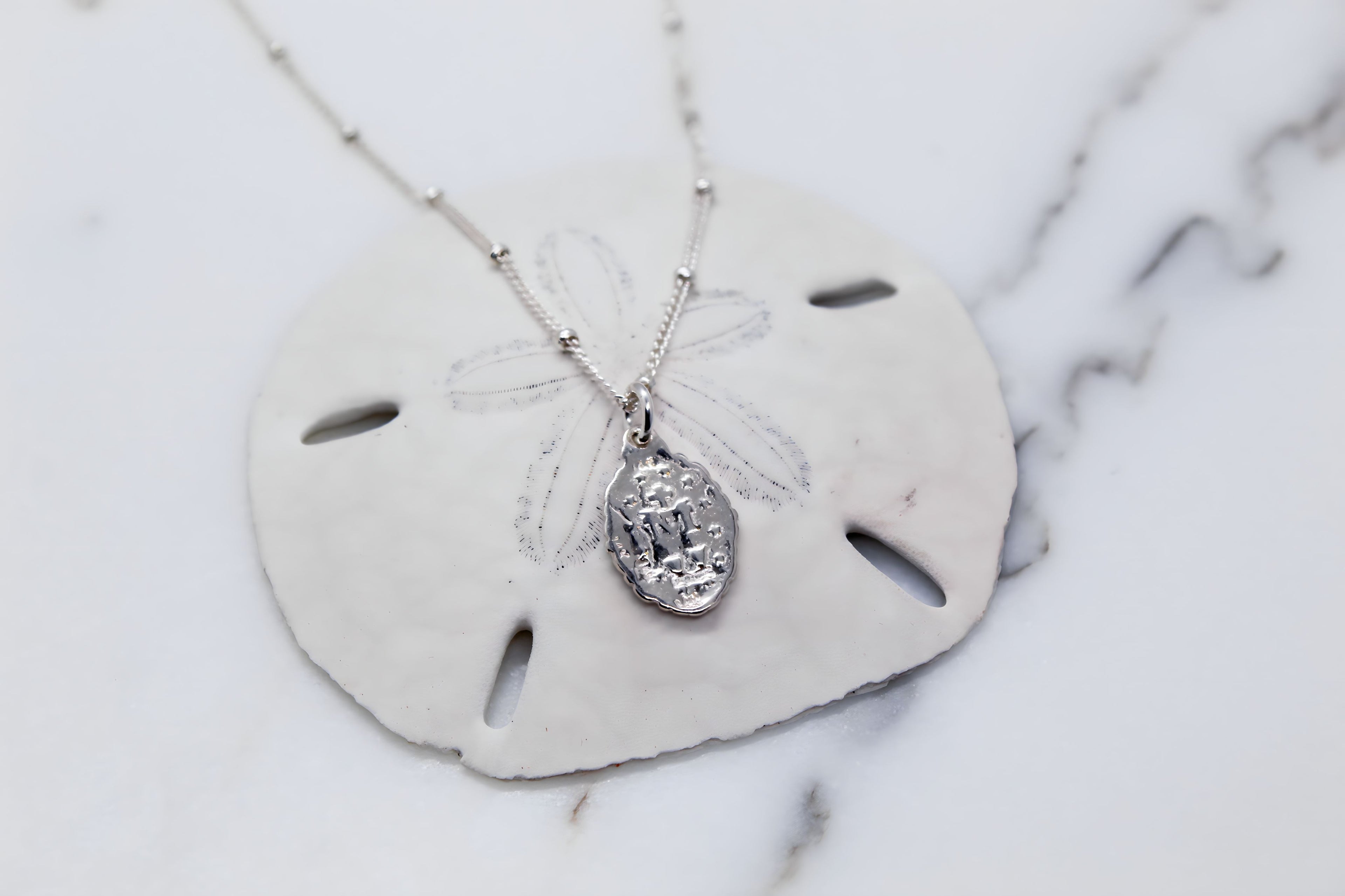 Silver-tone oval miraculous pendant necklace with detailed framed figure