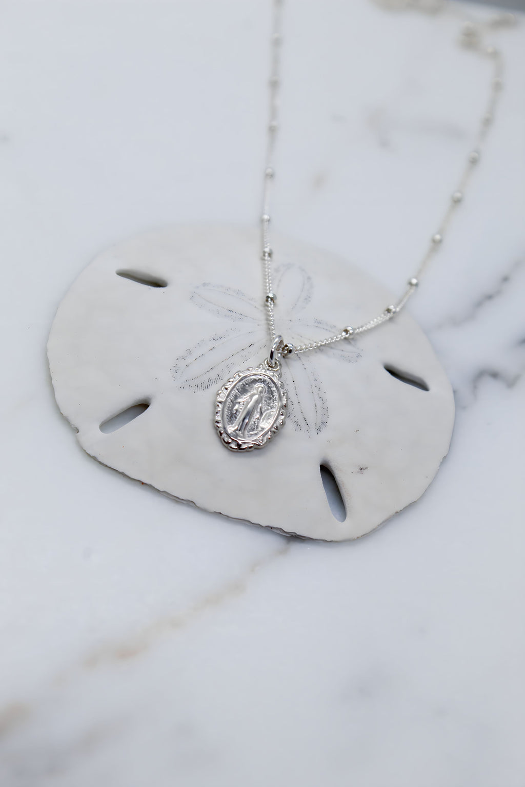Silver-tone oval medal pendant necklace with dangling oval centerpiece