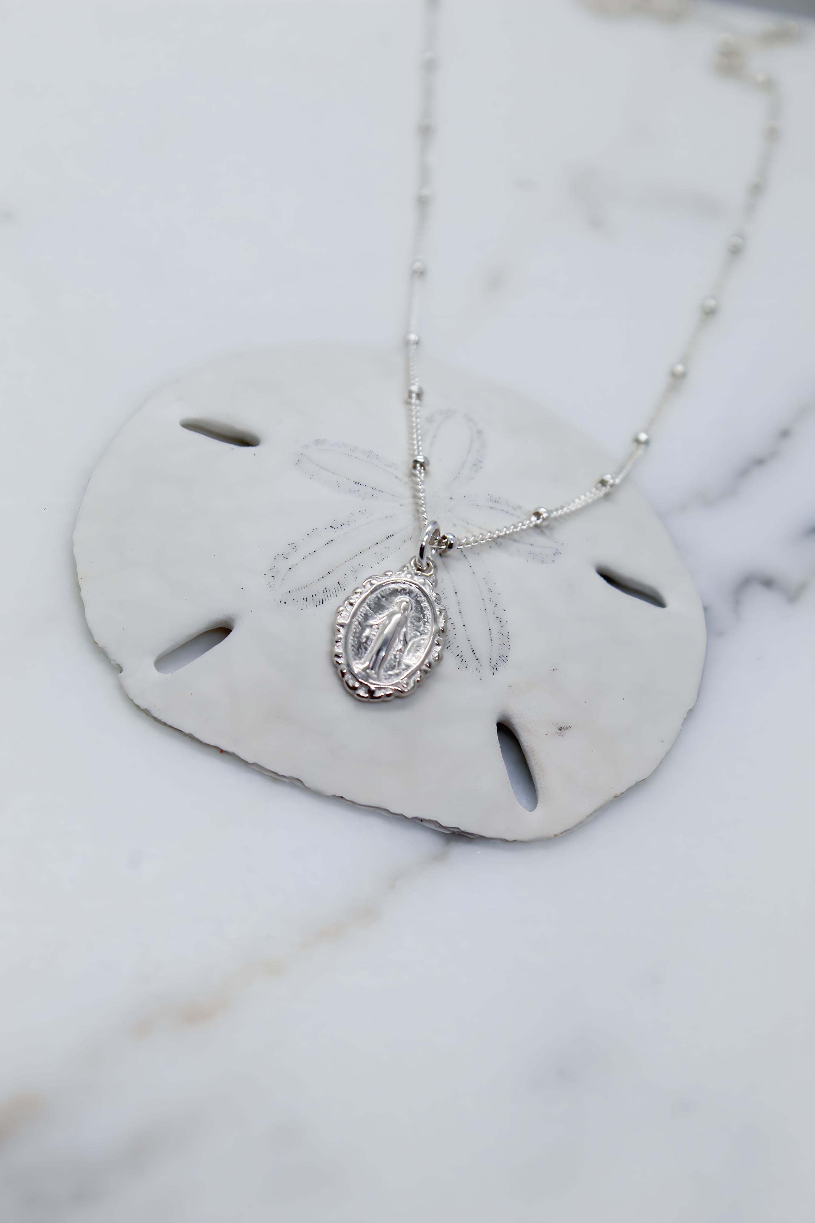 Silver-tone oval medal pendant necklace with dangling oval centerpiece