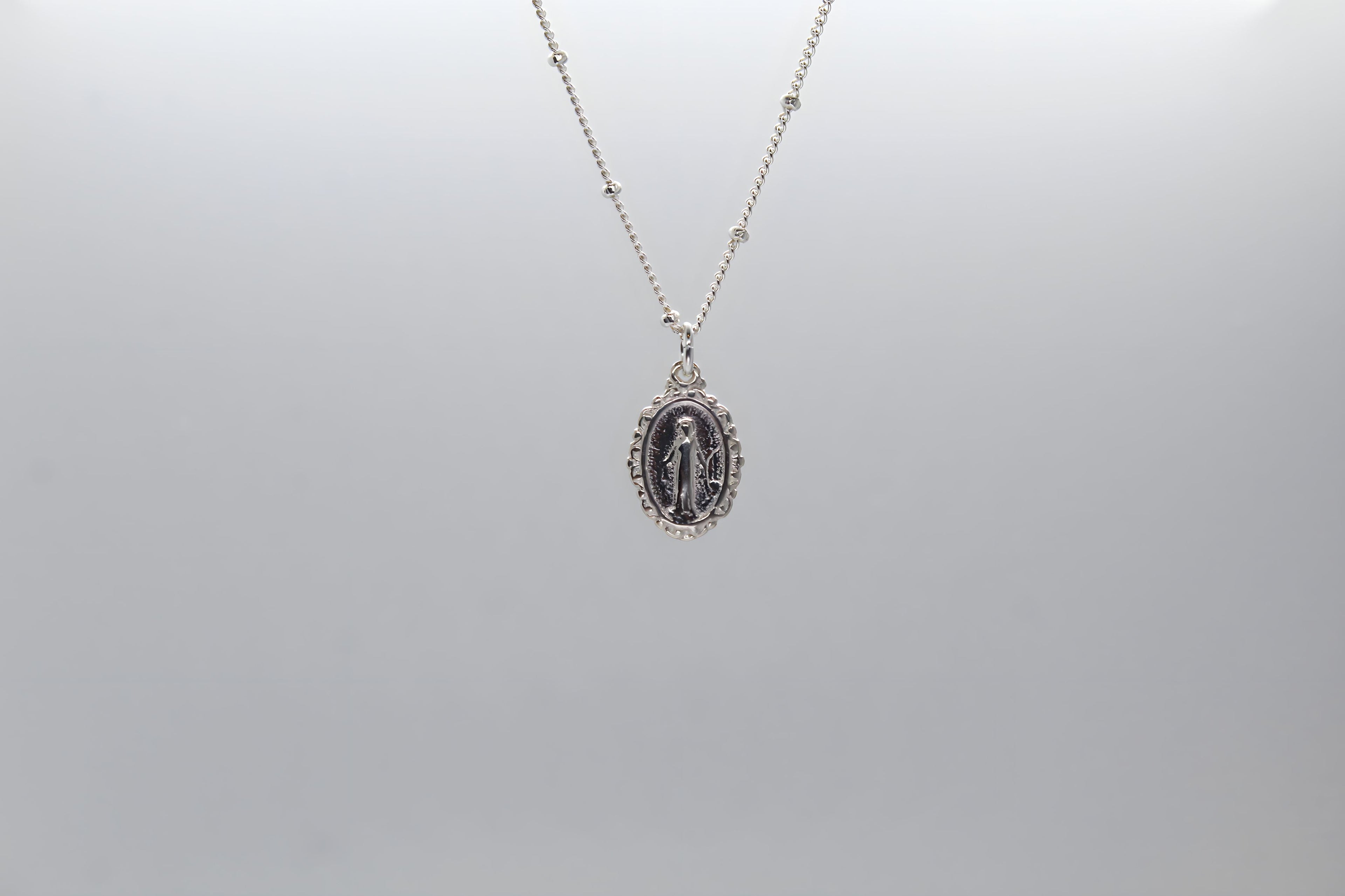 Silver-tone oval miraculous medal pendant necklace with thin chain