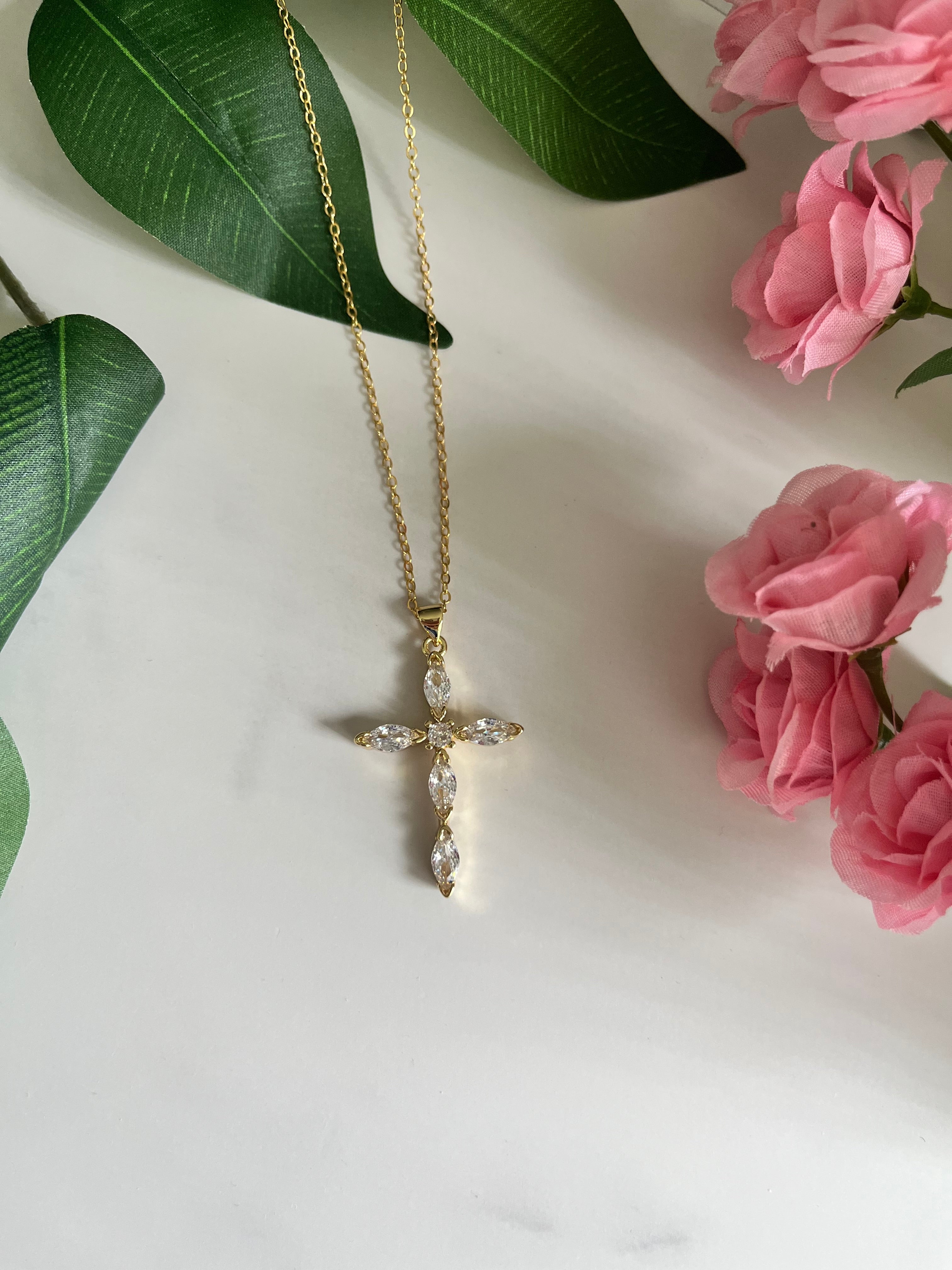 Gold cross pendant necklace with clear crystal stones on a fine chain