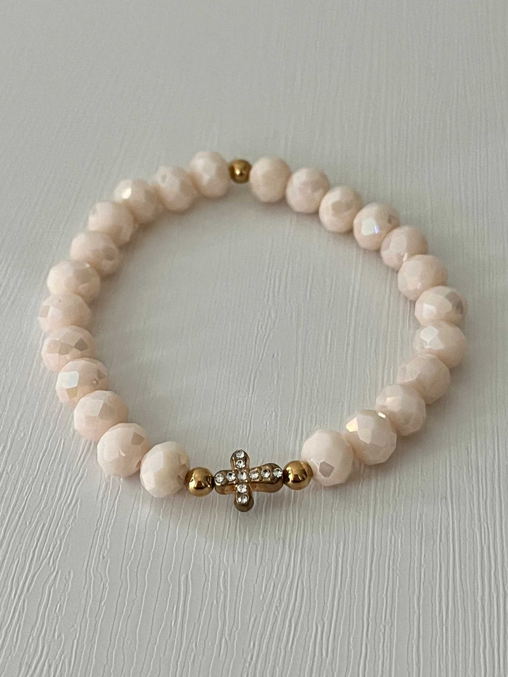 Beaded cross bracelet with pale pink round beads and rhinestone cross charm