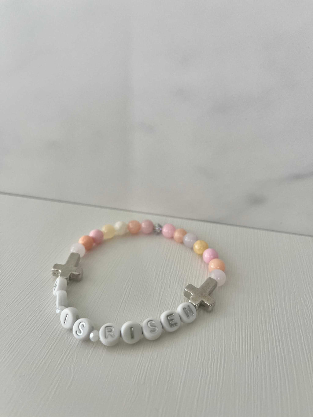 Pastel bead bracelet with 'HE IS RISEN' letter beads and silver cross charms