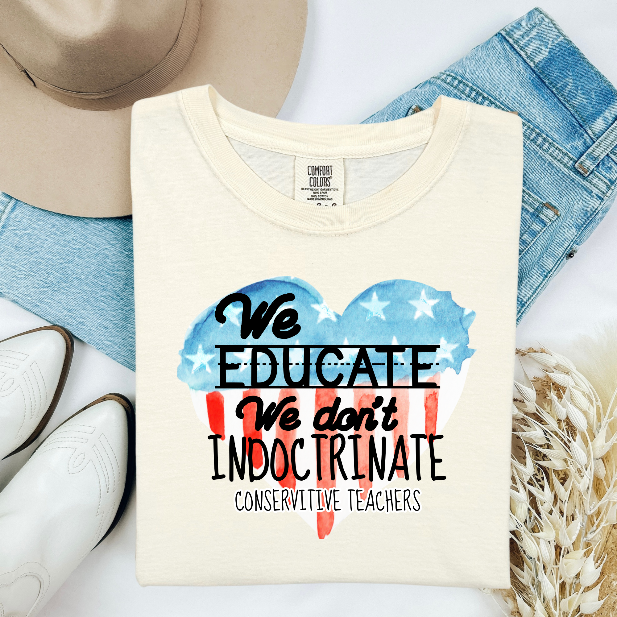 Ivory teacher T-shirt with 'We Educate' graphic and 'We don't indoctrinate' text