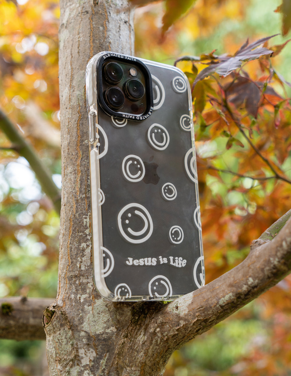 Dark phone case with circular smiley icons and Jesus is Life text