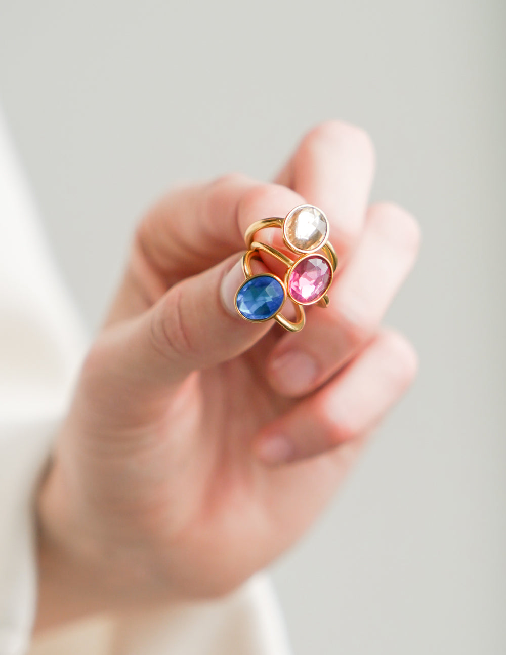 Gold ring with oval blue gemstone on finger