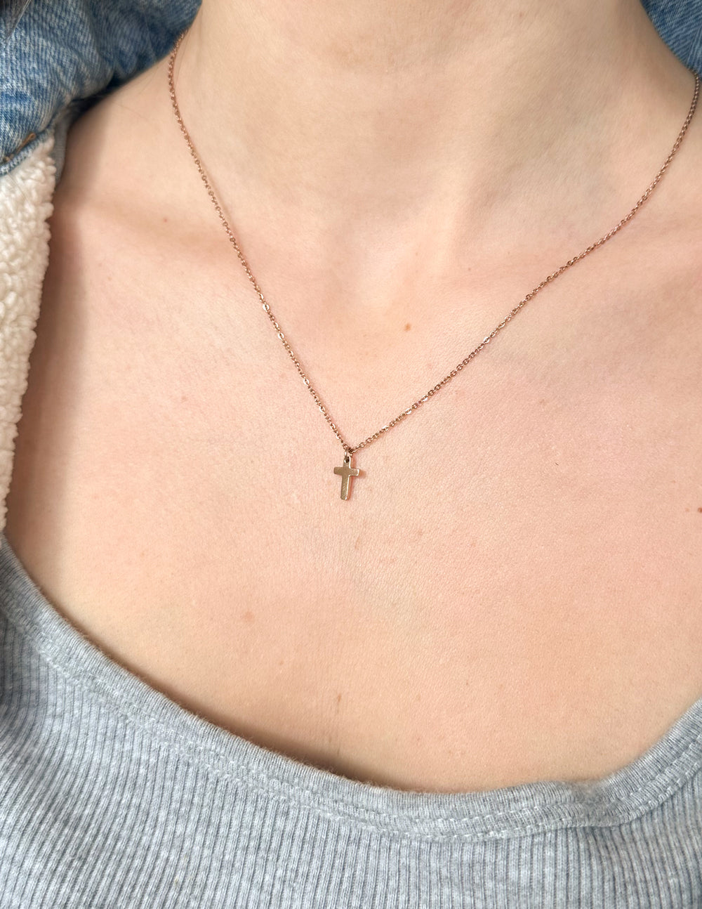 Rose gold cross necklace worn with small cross pendant on link chain