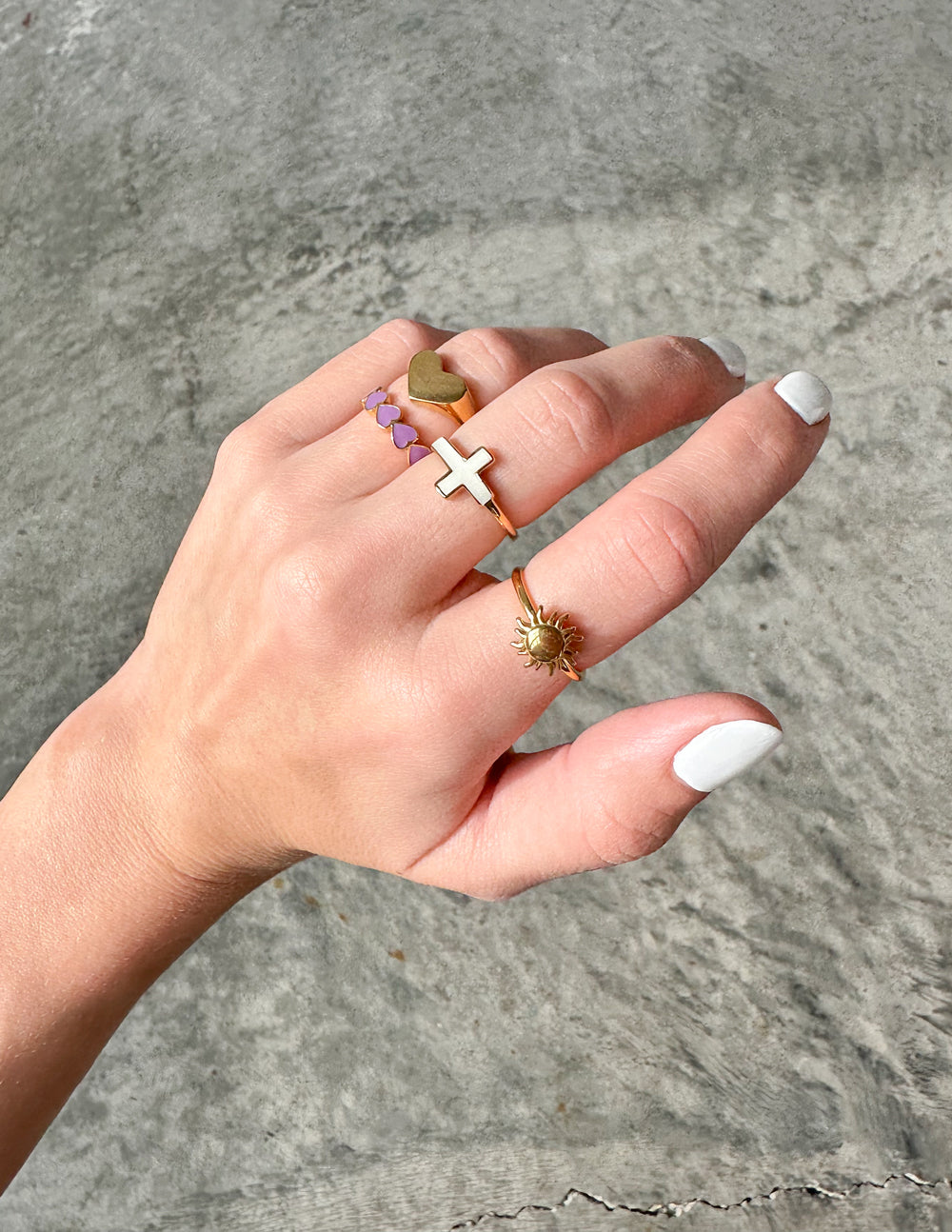 Gold heart signet ring with raised heart face on finger