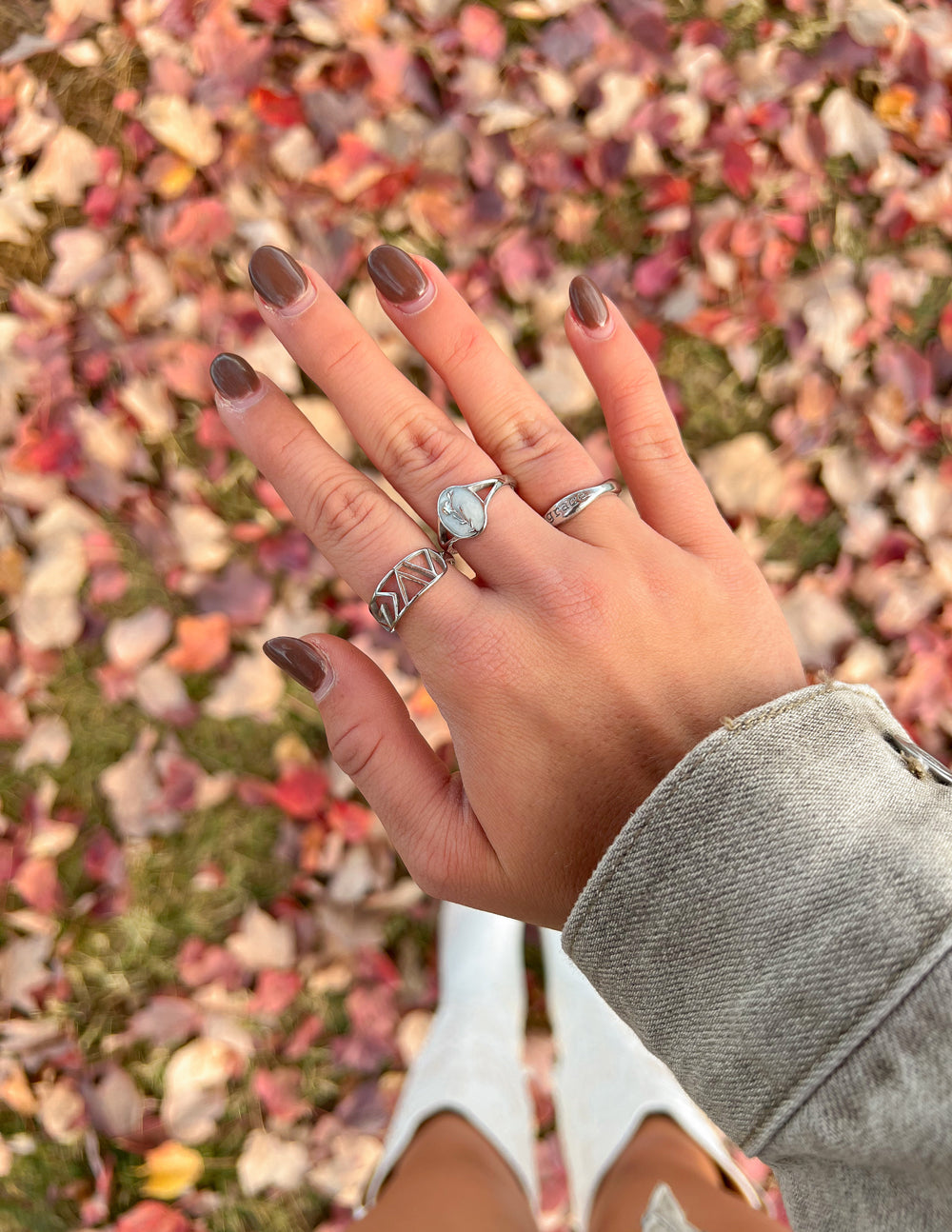 Silver geometric statement ring with raised band pattern, worn
