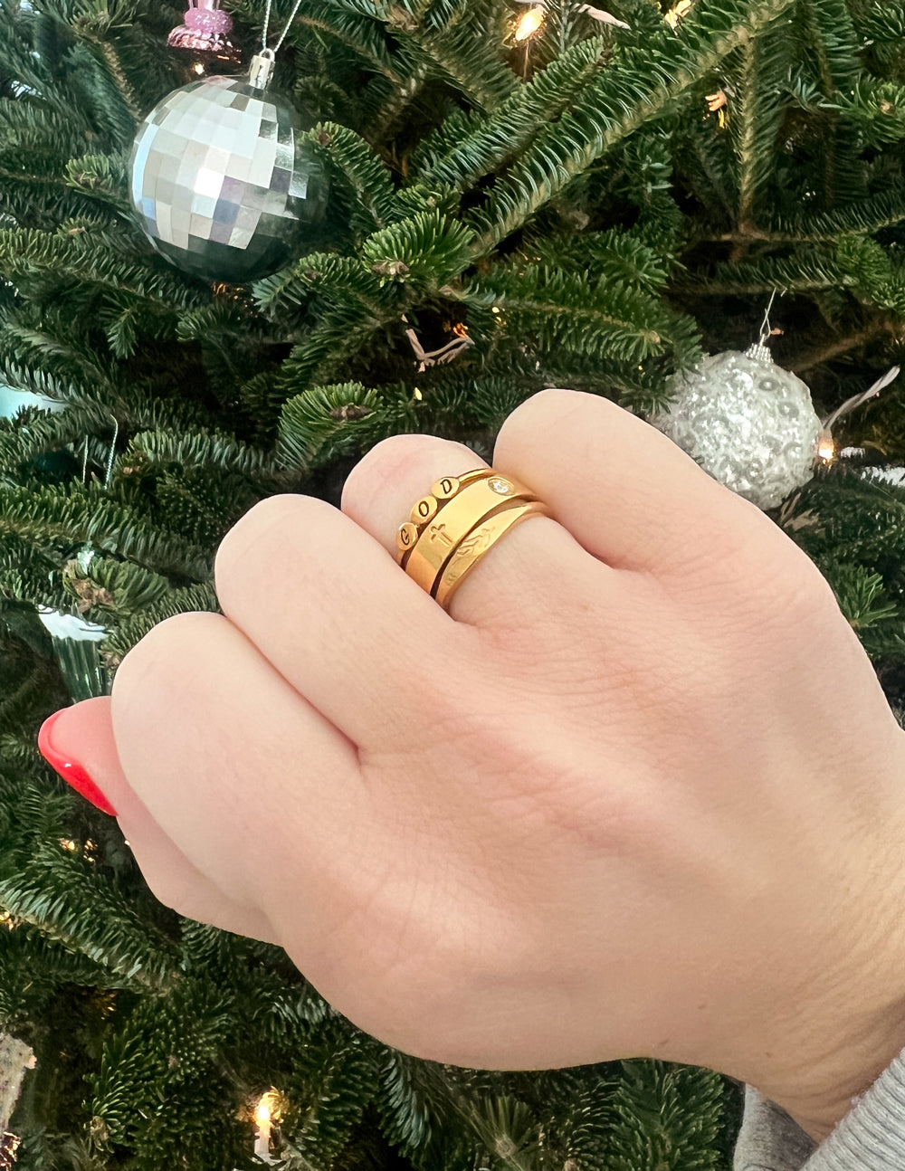 Gold vine ring on finger, smooth band with vine motif engraving