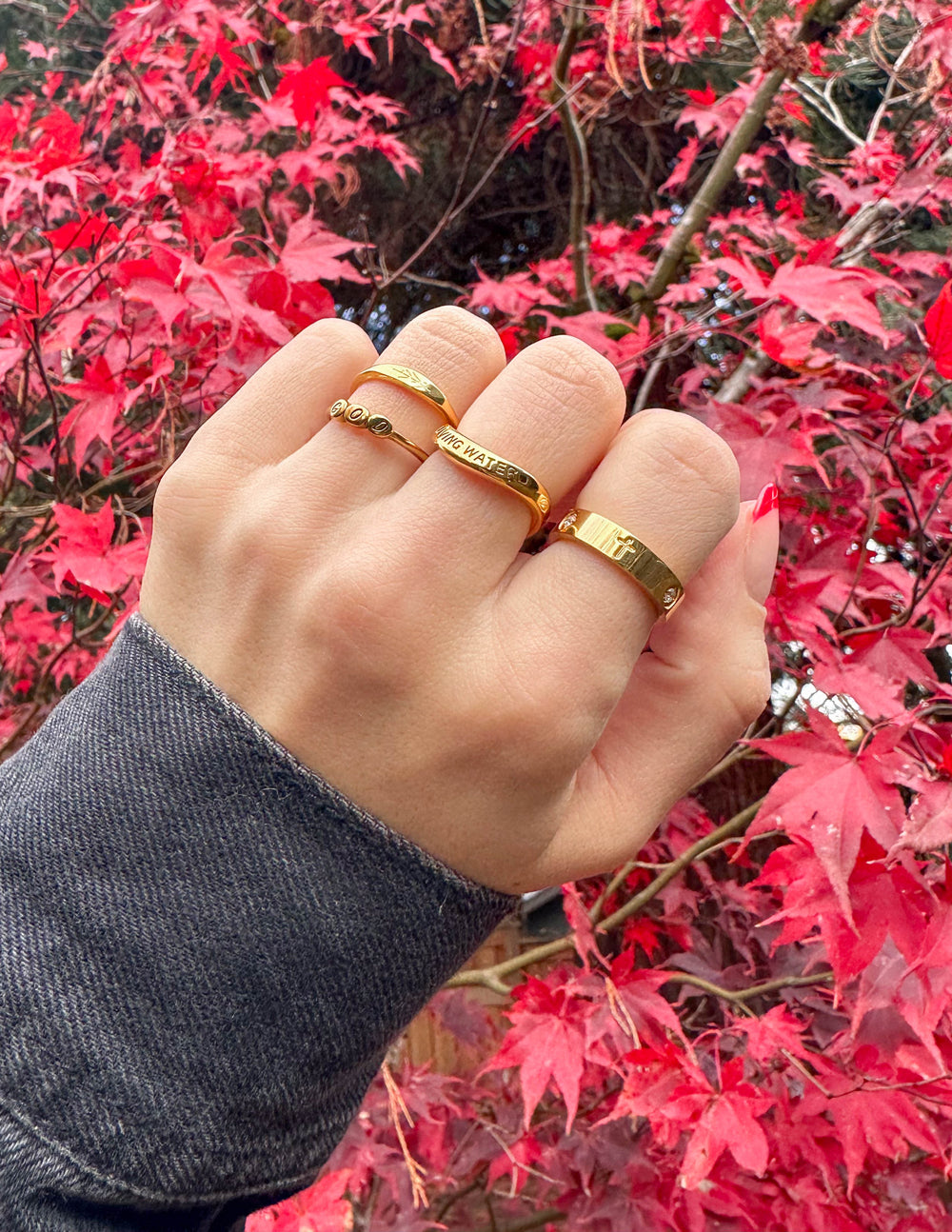 Gold vine ring on finger, thin band with engraved vine detail