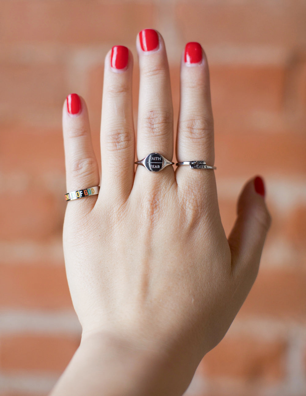Silver faith-over-fear ring with round face engraving, worn on hand