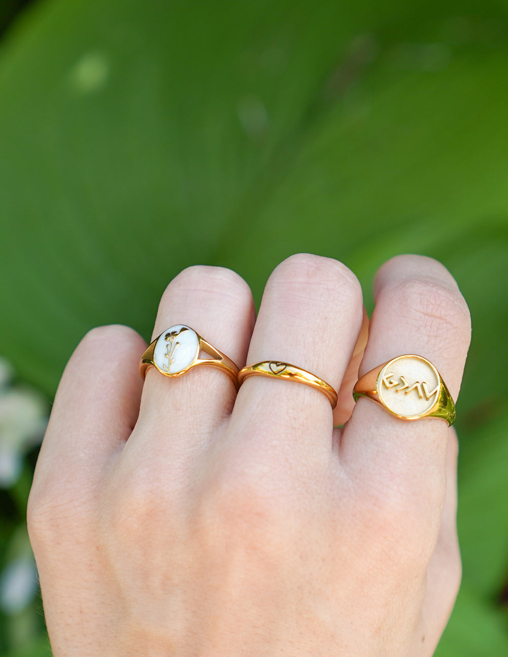 Gold-tone signet ring with engraved seal-like face on thin band