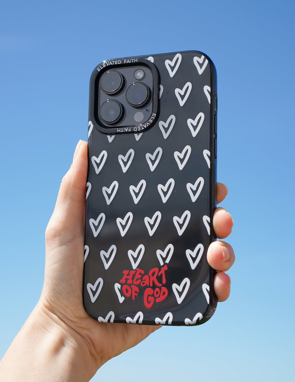 Black phone case with white hearts and red HEART OF GOD lettering