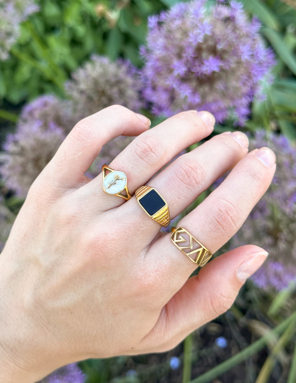 Gold statement ring with black oval face and geometric edge detailing