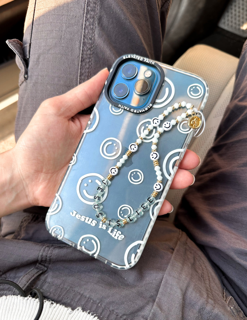 Blue phone case with smiley icons, Jesus is Life text, and bead charm