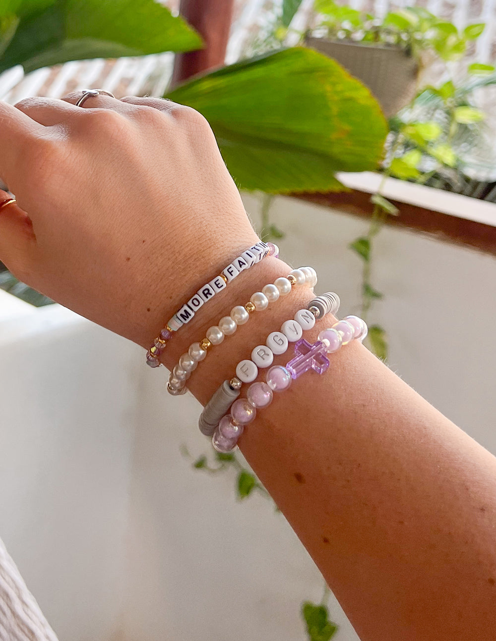 Multi-strand letter bracelet with alphabet beads, pearl-style beads, and light purple strand